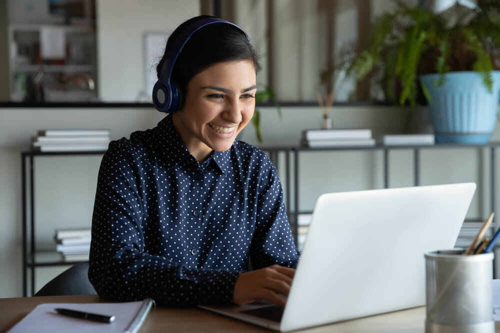 happy young woman studying on laptop