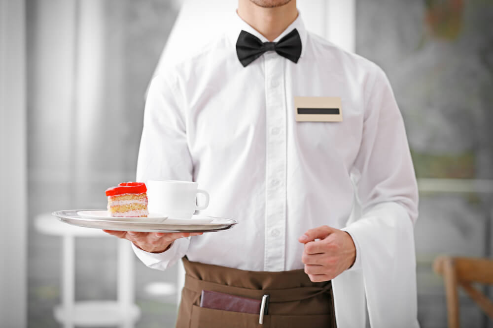 waiter in white bringing dessert