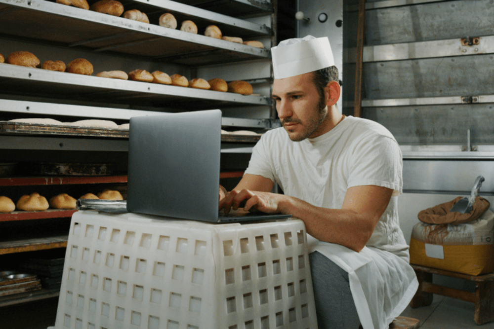 Baker student using a laptop for studying online courses in Patisserie