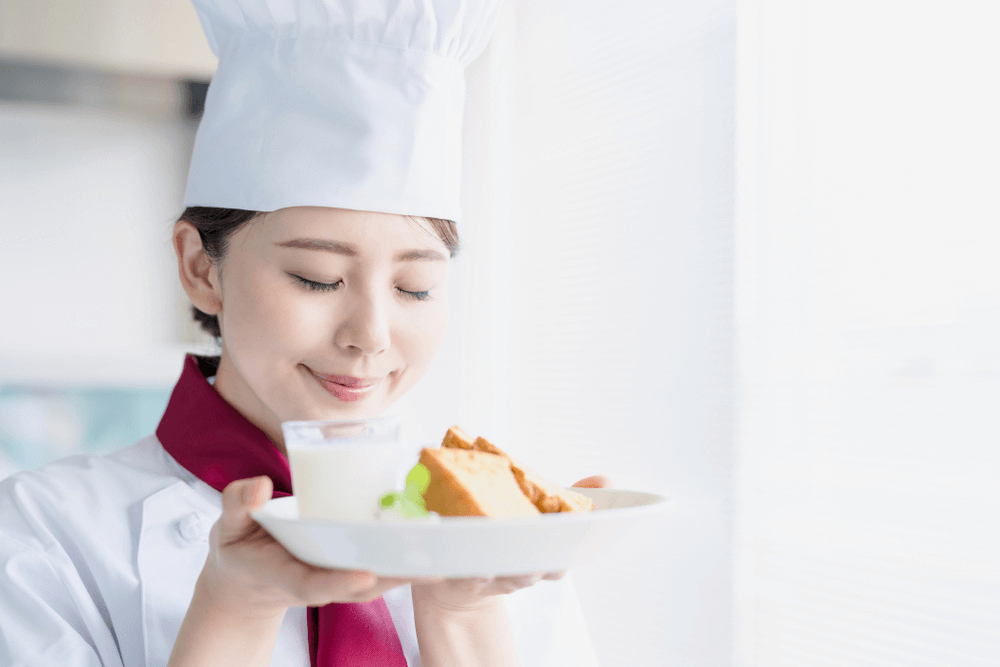 Female pastry chef appreciating good food