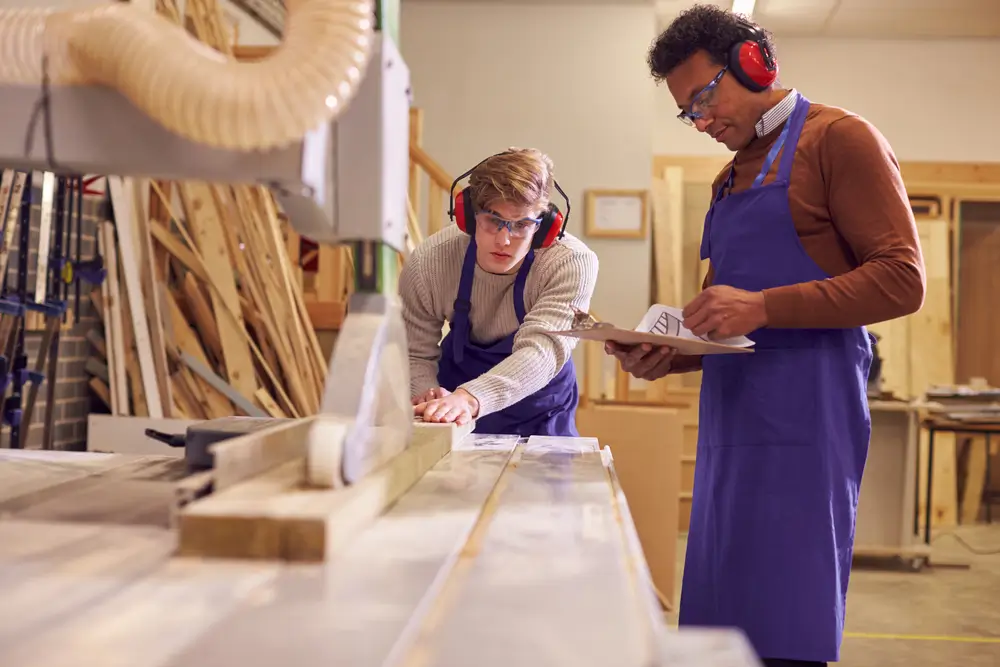 Carpentry instructor working with a student in a workshop