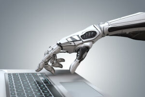 Robot hand symbolising generative artificial intelligence for educators and students typing on a laptop keyboard