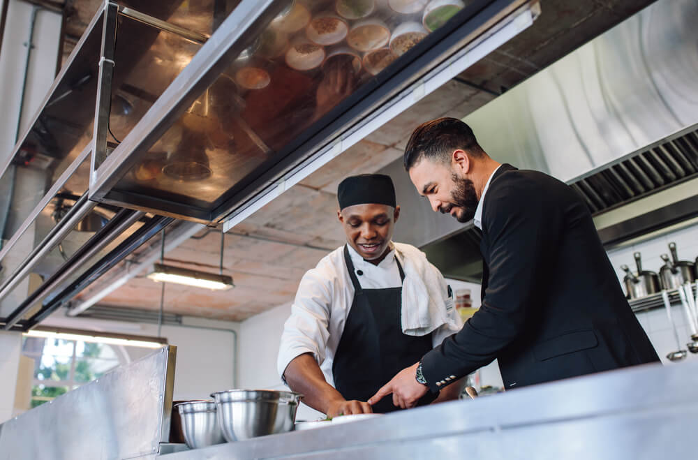 restaurant manager discussing with chef in kitchen