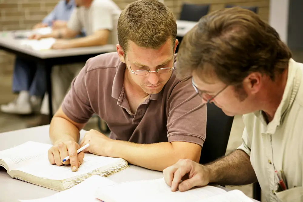 A student working with a vocational trainer during theoretical training
